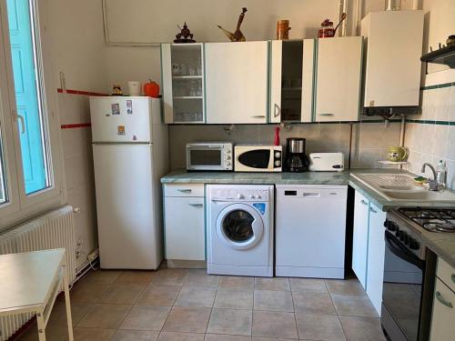 une cuisine avec un lave-linge et un lave-linge dans l'établissement Maison de village Canet en Roussillon proche mer, à Canet