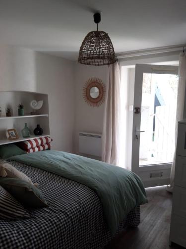 une chambre avec un lit, un miroir et une fenêtre dans l'établissement Bel Appartement St Malo avec jardin à 2 pas de la plage Sillon, à Saint-Malo