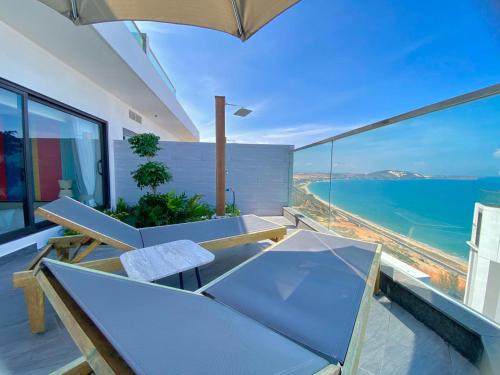 a balcony with a table and chairs and the ocean at APEC MANDALA Condotel in Phan Thiet