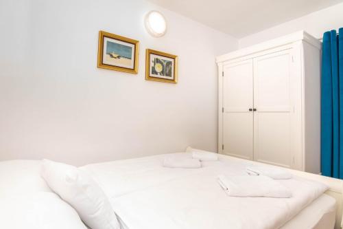 a white bedroom with a bed and a cabinet at Bed and Brekfast Donatella in Piran
