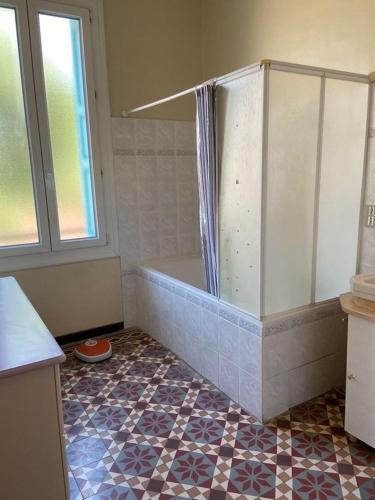 La salle de bains est pourvue d'une baignoire et de carrelage. dans l'établissement Maison de village Canet en Roussillon proche mer, à Canet