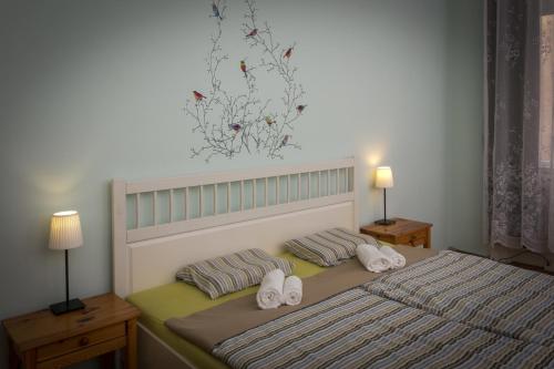 una camera da letto con un letto con due asciugamani e due lampade di Historic Rooms near Gozsdu Udvar a Budapest