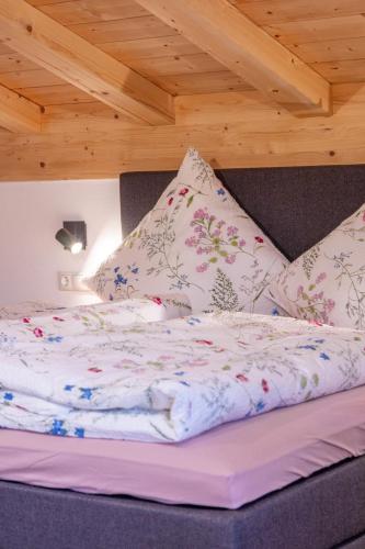 a bed with white sheets and pillows in a room at Ferienwohnung Hirnsberglehen in Bischofswiesen