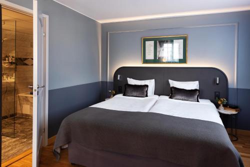 a bedroom with a large bed and a shower at Hotel Hasselbacken in Stockholm