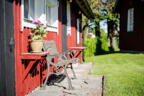 a bench sitting next to a red building with a window at precis intill Ombergs golfbana, nära till Vättern, stora Lund och Hästholmen in Ödeshög
