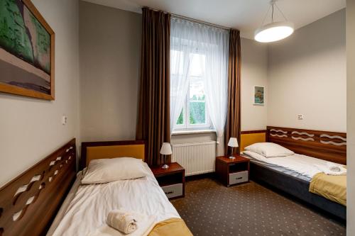 クリニツァ・ズドルイにあるNowe Łazienki Mineralneのベッド2台と窓が備わるホテルルームです。
