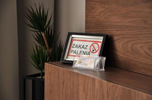 a sign sitting on top of a counter with a no smoking sign at Q Apart Meta -1, 2 lub 3-pokojowe, klimatyzowane apartamenty przy Manufakturze z garażem lub parkingiem Gratis, FV in Łódź