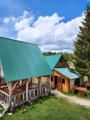 a log cabin with a green roof at Panoramic Bungalow in Uskoci