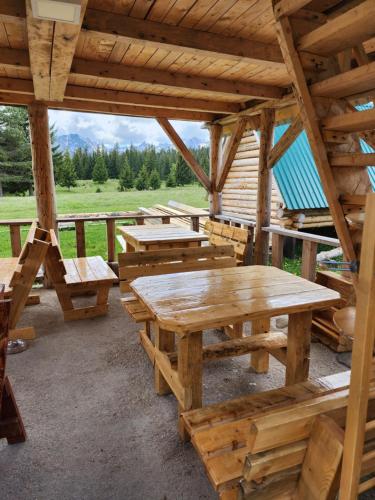 a group of picnic tables in a wooden cabin at Panoramic Bungalow in Uskoci