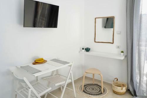 a white table and chairs in a room with a mirror at Sea View Studio at Xenios Avlais in Zakynthos Town
