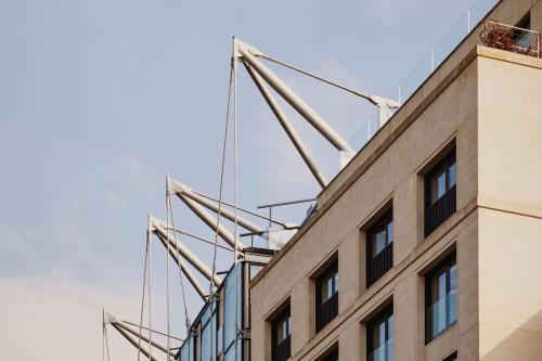 um edifício com guindastes grandes em cima em The Emory em Londres