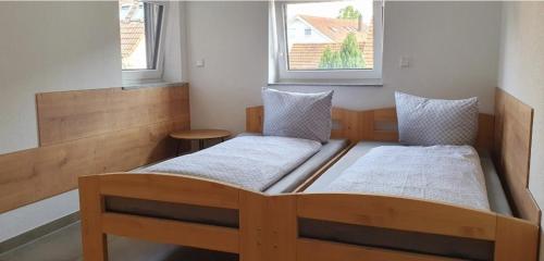 two beds in a small room with two windows at Eibauer Apartments in Sinsheim