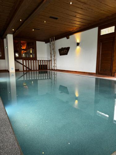 a swimming pool in a house with blue water at Residence Hôtelière La Renardiere in Samoëns