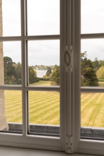 an open window with a view of a field at Les Garennes - Hôtel Spa Bénodet in Bénodet