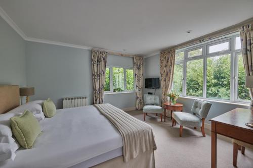 um quarto com uma cama, uma secretária e janelas em Fermain Valley Hotel em St Peter Port
