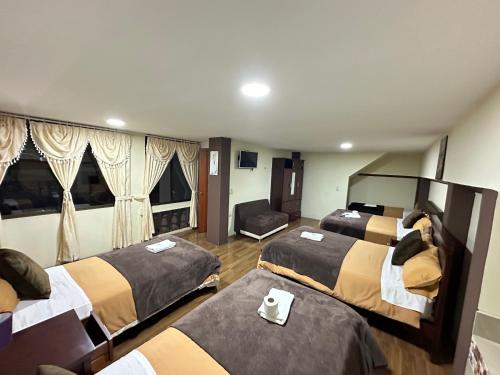une chambre d'hôtel avec trois lits et une chaise dans l'établissement Hotel Casa Santa Lucía, à Baños