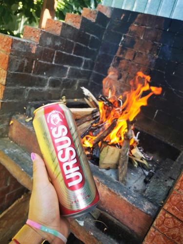 a person holding a can of coke in front of a fire at Casa Chitu in Murighiol