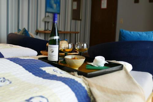 a tray with a bottle of wine and glasses on a bed at Zenner's Landhotel in Newel
