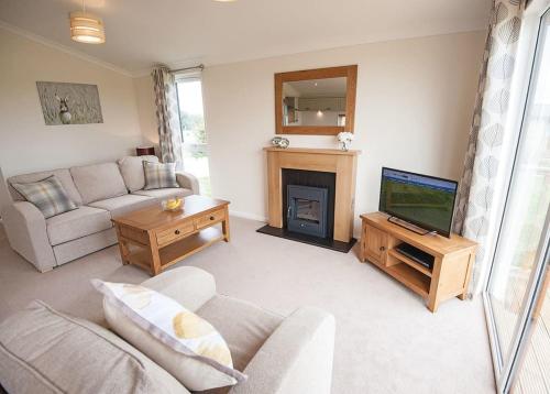 a living room with a couch and a television at Holderness Country Park in Tunstall