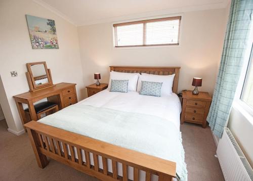 a bedroom with a large bed and two night stands at Holderness Country Park in Tunstall