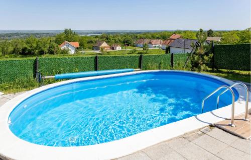 a large pool with blue water in a backyard at Awesome Home In Aljmas in Aljmaš