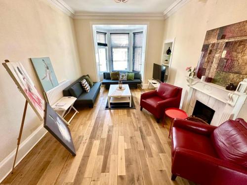 een woonkamer met rode meubels en een open haard bij Dumbarton cosy home, Loch Lomond in Dumbarton