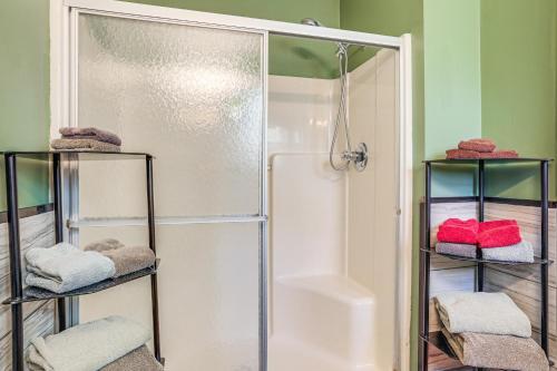 ein Badezimmer mit einer Dusche und Handtüchern auf Regalen in der Unterkunft Serene Presque Isle Harbor Home on Sunrise Side! in Presque Isle