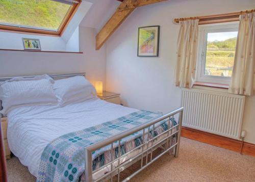 1 dormitorio con cama y ventana en Gwalia Falls en Aberporth