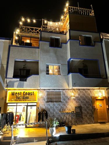 a building with a west coast surf shop at night at West coast surf house in Imsouane