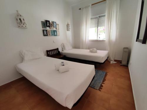 a white room with two beds and a couch at Vilas Marrocha in Porches