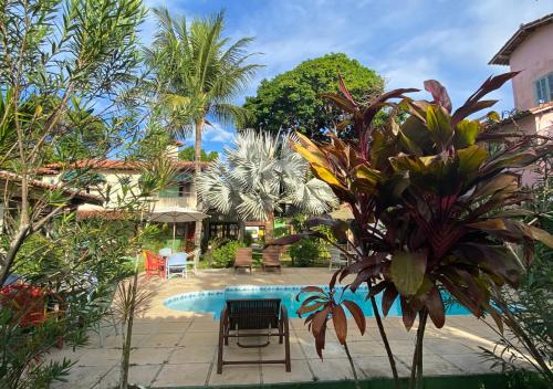a swimming pool in a resort with a table and chairs at Pousada Cantinho do Sossego in Arraial d'Ajuda