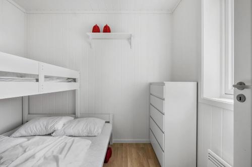 a white bedroom with a bed and a dresser at Voss Resort self-service apartments in Skulestadmo