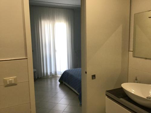 ノート・マリーナにあるB&B Villa Taniaのバスルーム(シンク、ベッド1台付)、窓が備わります。