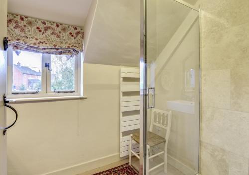 een douche met een glazen deur naast een raam bij Whitewalls in Snape