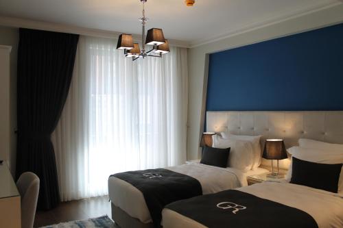 a hotel room with two beds and a blue wall at Garlon Residence in Istanbul