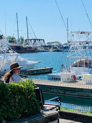 a woman sitting on a bench at a marina at Casa Amable - Manuel Antonio in Quepos