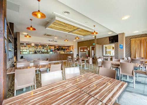 um restaurante com mesas e cadeiras e um bar em Freshwater Beach Holiday Park em Burton Bradstock