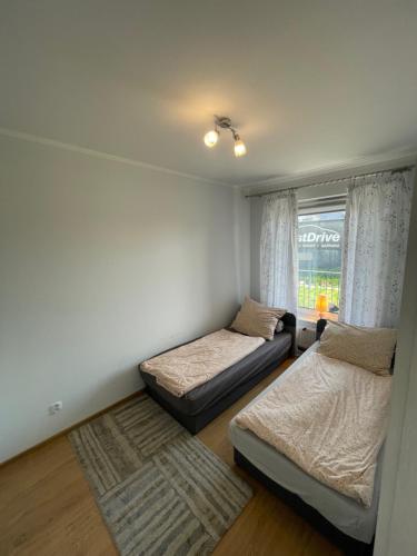 een slaapkamer met 2 bedden en een raam bij Akwamaryn apartment in Kołobrzeg