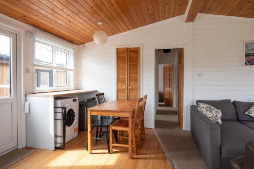 a kitchen and living room with a table and a couch at East Chalet At Tapnell Farm in Yarmouth
