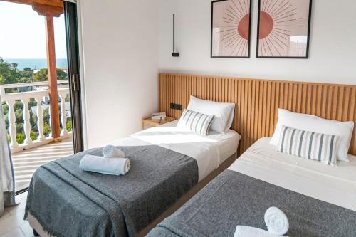 two beds in a hotel room with a balcony at Relaxing Sea View Studio at Xenios Avlais in Alikanas