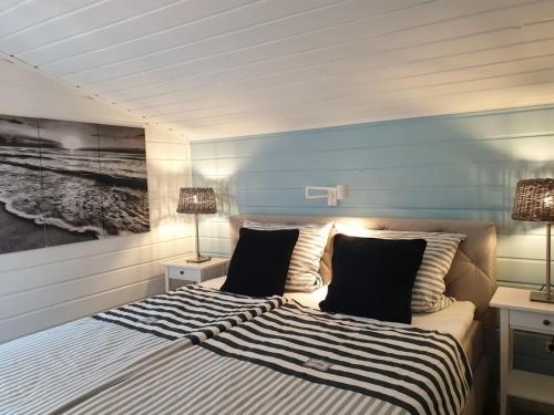 a bedroom with a bed with a painting on the wall at Ferienhaus Grosses Meer mit Ruderboot in Südbrookmerland