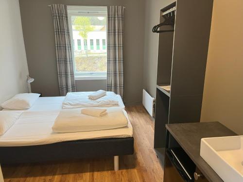 Habitación pequeña con 2 camas y ventana en Birkelunden Bed & Breakfast en Rjukan