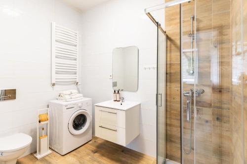a bathroom with a washing machine and a shower at Apartment Quiet Street 11/1E in Oświęcim