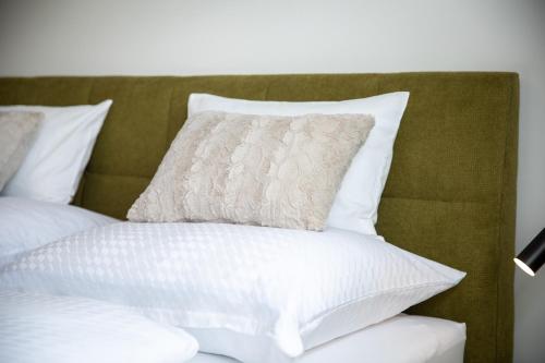 a bed with white pillows on top of it at Ferienwohnung Silvia, Mondsee Zentrum in Mondsee