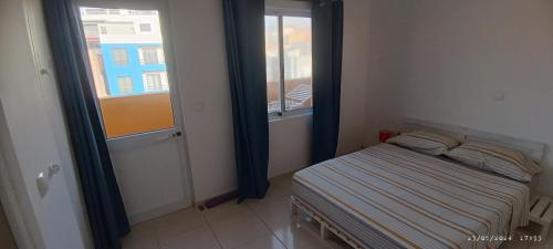 1 dormitorio pequeño con 1 cama pequeña y ventana en Óscar guest house, en Mindelo