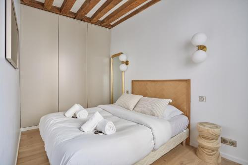 a large white bed with white pillows in a room at Eiffel Tower Apartment/Invalide by Studioprestige in Paris