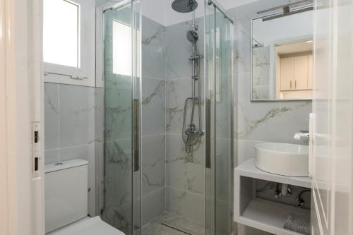 a bathroom with a glass shower and a sink at Dallas Hotel in Svoronata