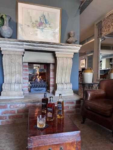 a living room with a fireplace with two bottles on a table at Bushmills Townhouse in Bushmills