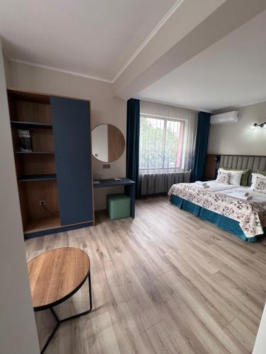 1 dormitorio grande con 1 cama y 1 mesa en Family Hotel Neliya, en Velingrad