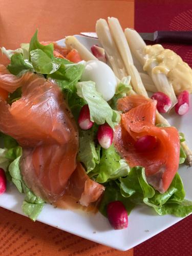 une assiette blanche avec une salade avec de la viande et des frites dans l'établissement Maison des roses, à Oullins
